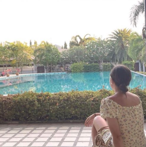 Femme assise seule au bord d’une piscine, moment de recul et de réflexion