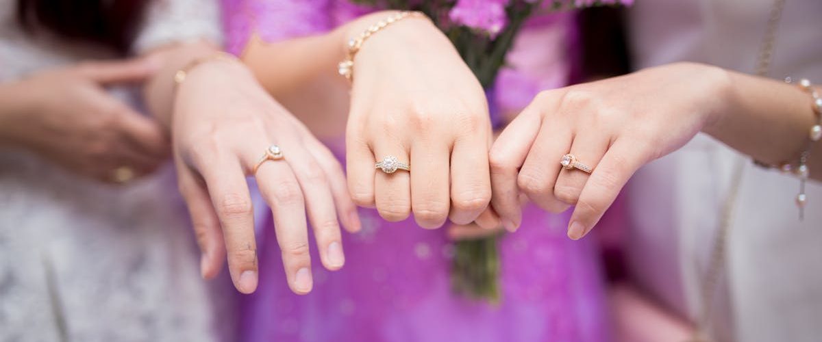 Trois femmes avec des bagues de fiançailles — une image symbolique du regard social sur le mariage